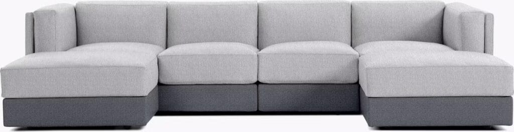 Modern gray sectional sofa with plush cushions and a sleek design, featuring contrasting dark gray base.