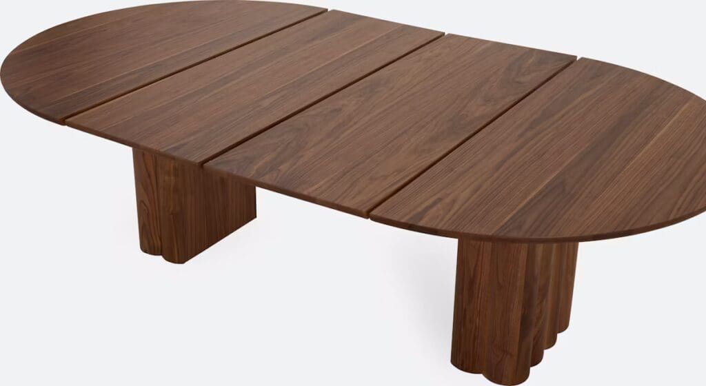 Large, oval wooden coffee table with a polished surface and thick, rounded legs.